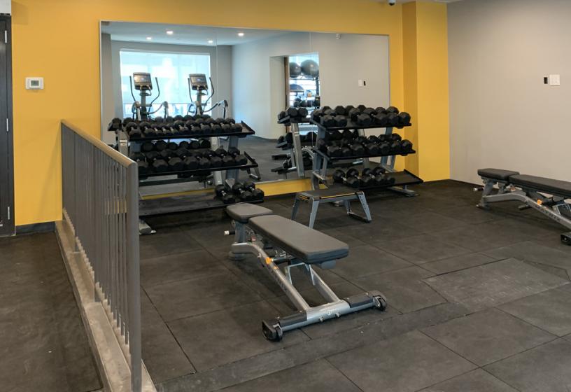Onsite fitness room with cardio and weight training equipment.